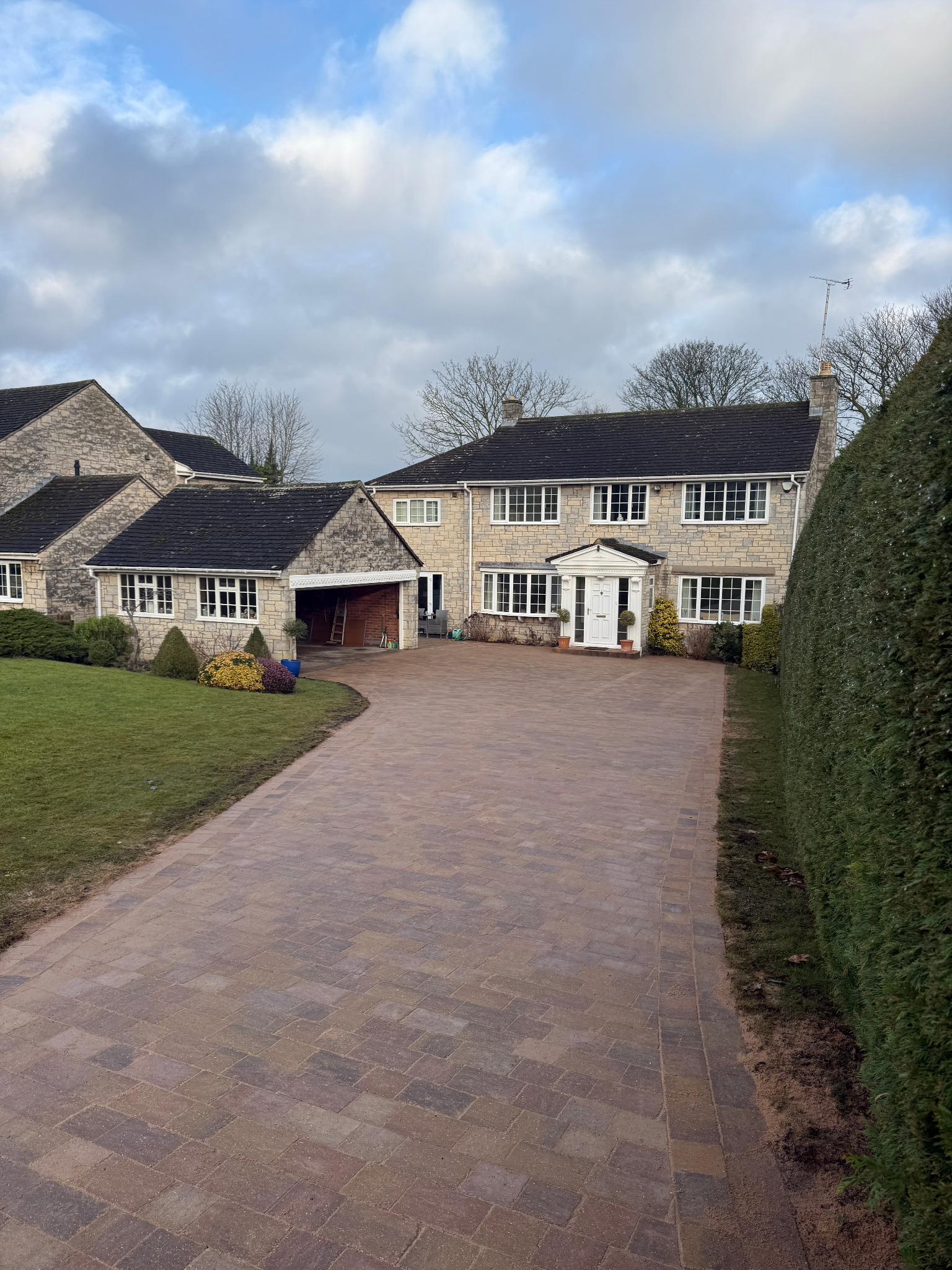 Premium porcelain-style paving and landscaped retaining wall