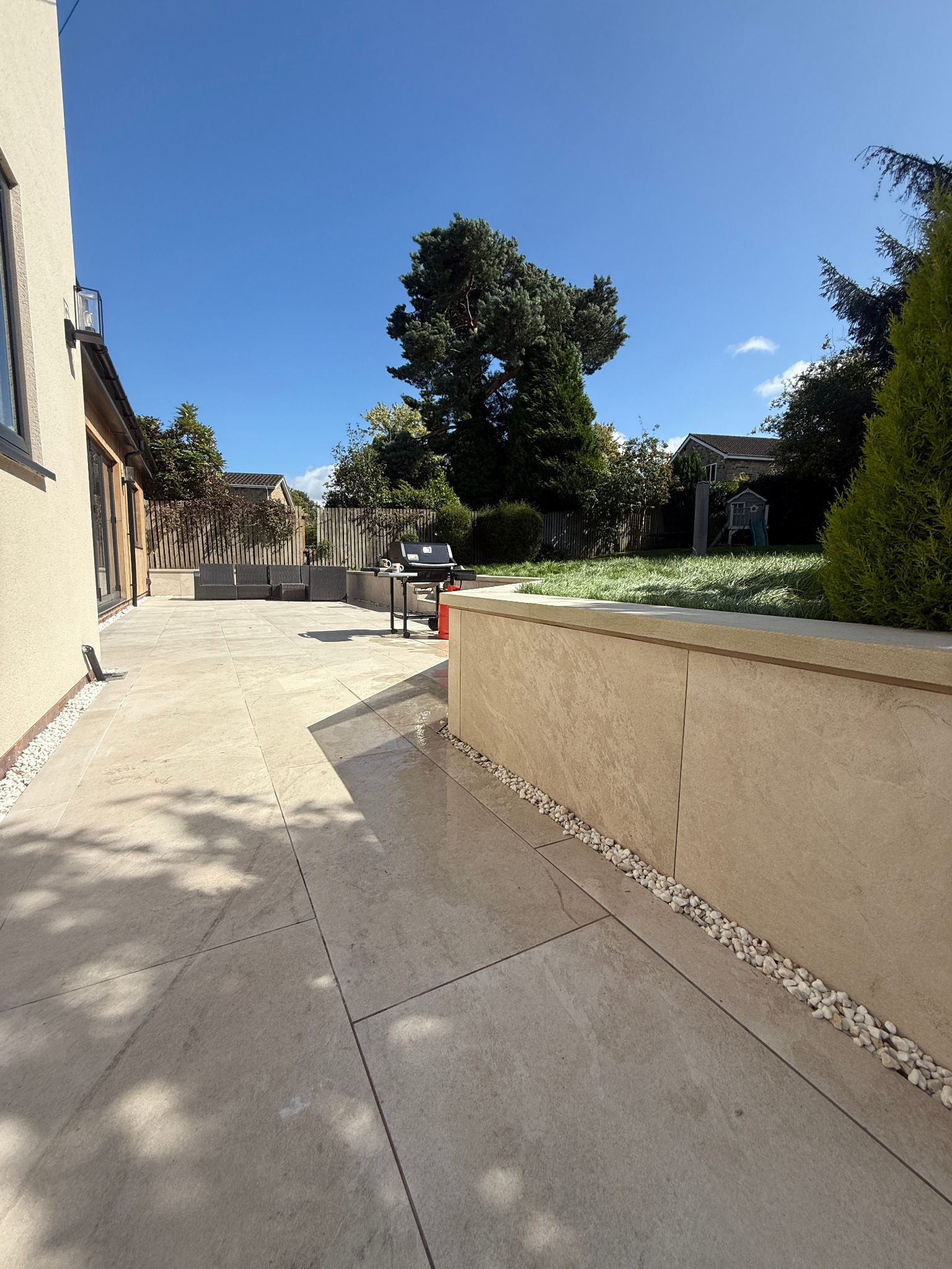 Premium porcelain-style paving and landscaped retaining wall