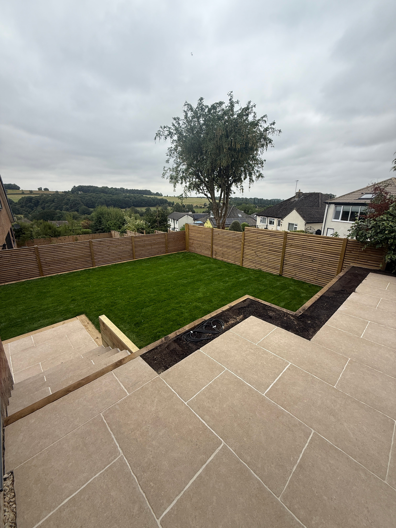 New lawn, timber fencing and paved terraces in a Yorkshire garden