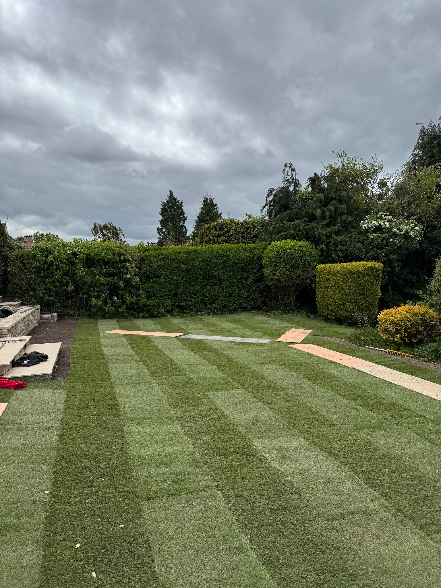 Premium porcelain-style paving and landscaped retaining wall