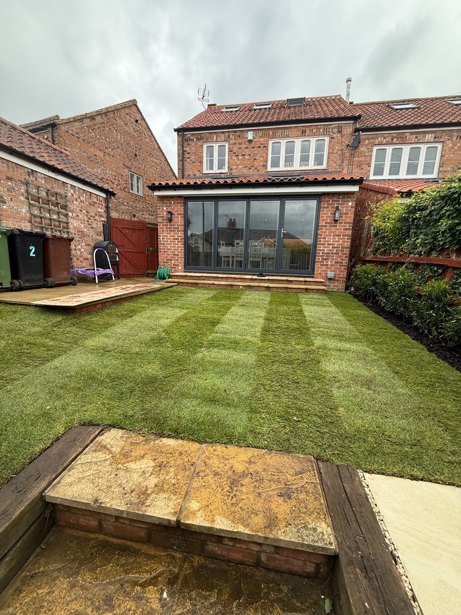 New lawn, timber fencing and paved terraces in a Yorkshire garden